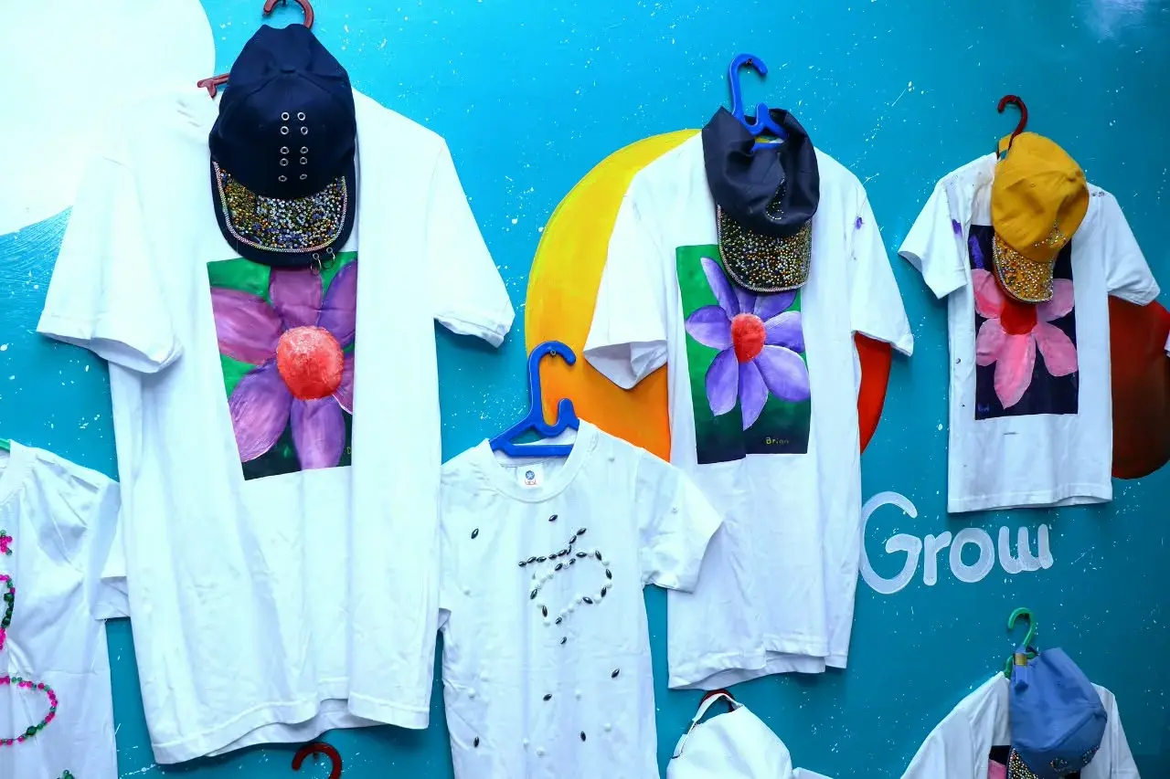 Hand-decorated white shirts hanging on a blue classroom wall